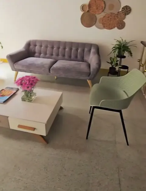 Sala de espera con sofá gris y mesa de centro